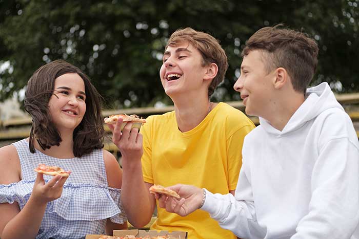 Jugendliche teilen sich eine Pizza